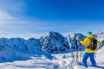 Fototapeta na wymiar Mountaineer backcountry ski resting along a snowy ridge with ski