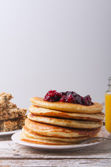 Stack of pancakes with glass of orange juice