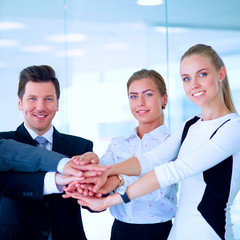 Fototapeta na wymiar Business team joining hands together standing in office