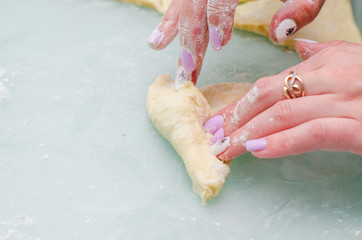 Fototapeta premium Girl makes homemade cinnamon buns, sliced rolls of dough roll. View from above, hands in picture