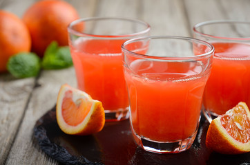Fresh blood orange juice on wooden background, selective focus