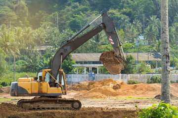 Excavator digging and removing earth .
Digger machine adjusting ground level in construction site.

