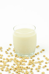 Milk with soy beans on white background.