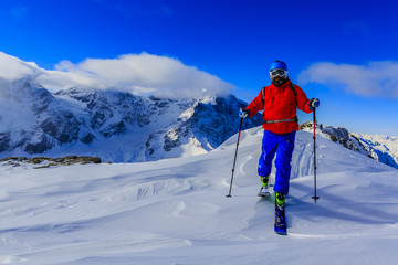 Fototapeta na wymiar Mountaineer backcountry ski walking up along a snowy ridge with