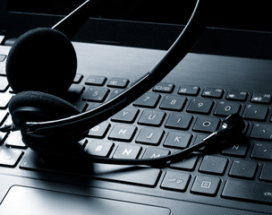 online communication: headphone set over laptop keyboard