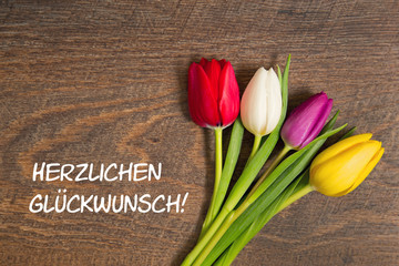 Tulpen auf Holzhintergrund: Herzlichen Glückwunsch