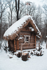 The hut stands in the woods in winter snow
