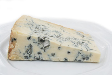 Fetta di gorgonzola su piatto su sfondo bianco