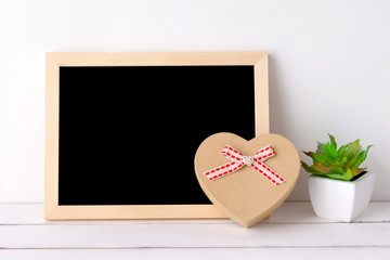 Blank Chalkboard and vintage heart shape gift box on white table