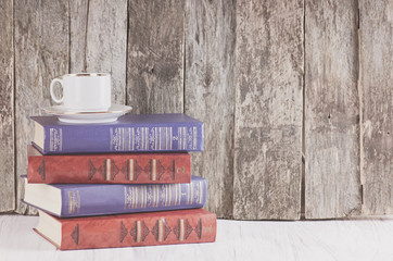 pile of old books on a wooden retro background and a white worktop