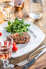 Beef Steak. Juicy beef steak. Gourmet steak with vegetables and glass of rose wine on wooden table.