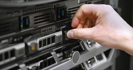 IT technician install harddrive in blade server in datacenter