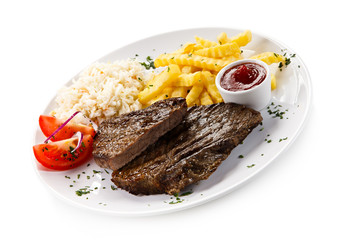 Grilled steaks, French fries and vegetables