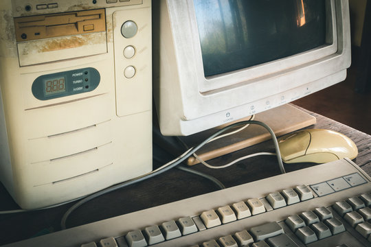 Close-up Of Ancient Old And Obsolete Personal Computer Home Use On Old Table Wood. Obsolete Technology Concept.