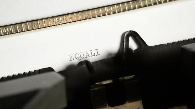 Typing the word EQUALITY with an old manual typewriter