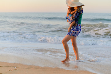 Back side view of mother and child walking on sandy beach sunset outdoors background