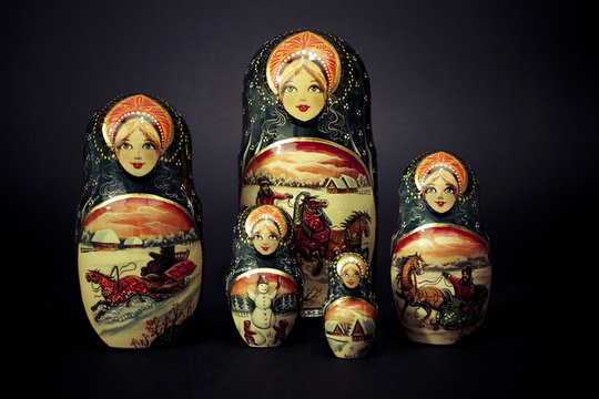 Matryoshka - Pieces of wooden Russian nesting doll isolated on dark background. Still-life picture taken in studio with soft-box.