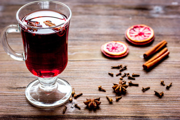 mulled wine with spices in cup on wooden background