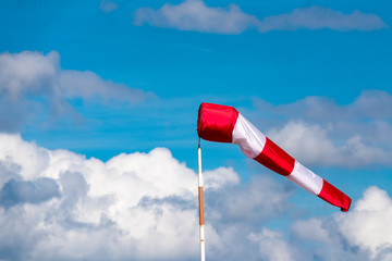 GREFRATH, GERMANY - SEPTEMBER 03, 2016: White and red coloured wind hose in front of blue sky with white clouds