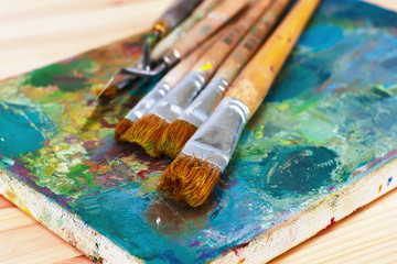 Fototapeta premium artist's palette with oil paints and brushes