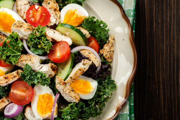 Fresh salad with chicken, tomatoes, eggs and lettuce on plate