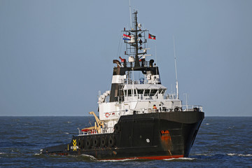 schwarzer Offshore Schlepper fährt in den Hafen von Rotterdam ein