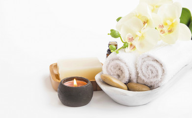 Obraz na płótnie Canvas Spa setting with orchid flower , candle, soap and towels on whit