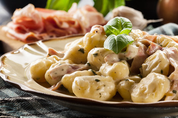 Potato gnocchi, Italian potato dumplings with cheese sauce, ham
