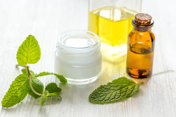 organic cosmetics with herbal extracts of mint on wooden background