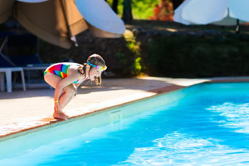 Little girl jumping into swimming pool