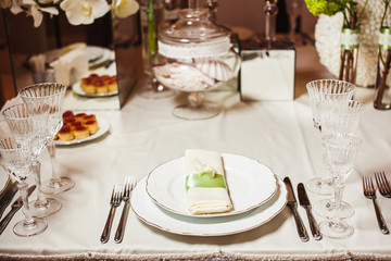Served table with dishes, utensil, cutlery and dishware on tablecloth