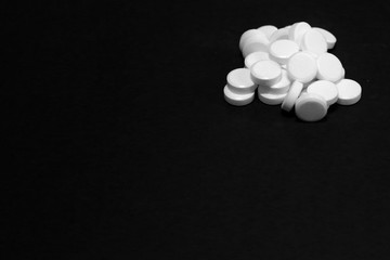 Fototapeta na wymiar White pills, medicines, on a blach background