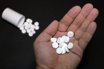 White pills, medicines, on a blach background