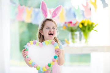 Obraz na płótnie Canvas Little girl in bunny ears on Easter egg hunt