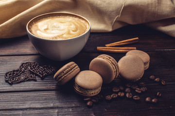 Fototapeta na wymiar Coffee with macarons and chocolate in the shape of heart.