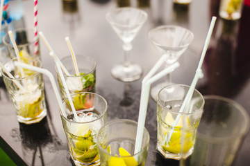 Cocktails with sipping straw on table. Refreshing alcoholic nonalcoholic beverages