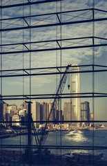 Construction in Hong Kong with the skyscrapers of the Central district at dawn seen through a large window. The tallest building in the frame is the IFC, International Finance Centre, building.