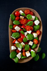 caprese salad on dark wooden surface