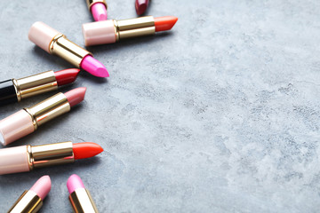 Fototapeta na wymiar Colorful lipsticks on grey wooden table