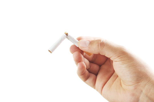 Male hand breaking the cigarette on white background