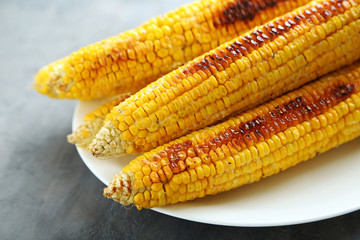 Tasty grilled corn on grey wooden table