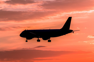 Airplane landing at sunset