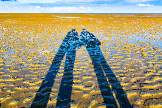Paar im Wattenmeer bei Abendstimmung