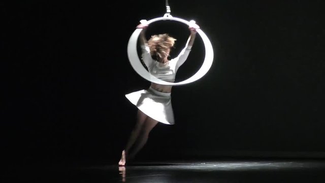 Mujer acr&oacute;bata girando en el aro a&eacute;reo, chica bailarina actuando en el teatro