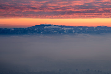 Fototapeta na wymiar Fiery skies above the morning mist - beautiful winter landscape on a mountain top