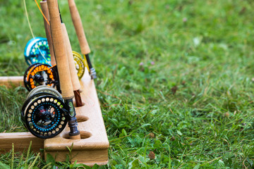 fishing rods with reels for fly fishing on a wooden stand