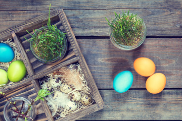 Happy easter holiday concept. Colorful chicken eggs quail eggs germinated wheat in glass jar branch...