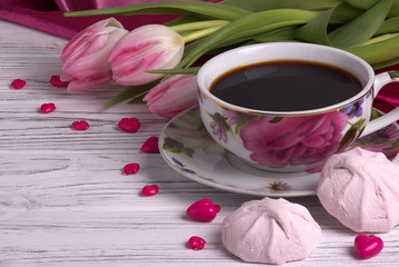 Valentine's day elegant still life with tulip flowers cup of coffe marshmallow red heart shape sign on white wooden background