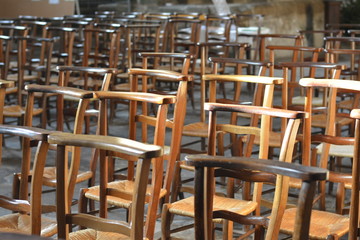 Wooden chairs inside a old church in France.