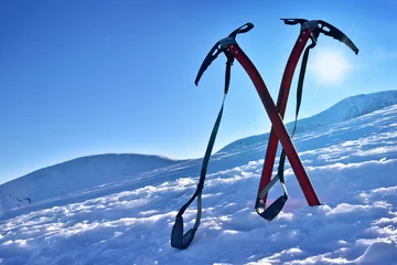 Gordijnen Pair of ice axes on mountain slope © aboutfoto